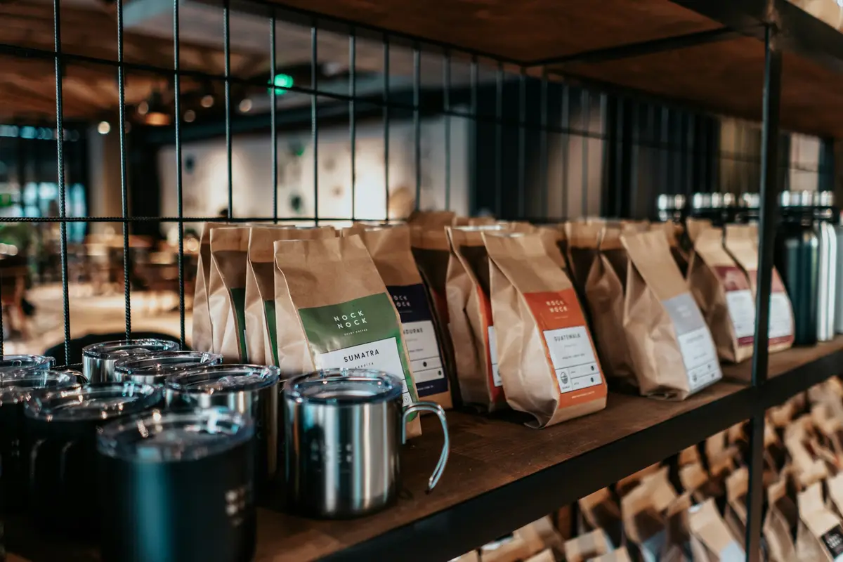 Coffee bags arranged on a wooden shelf in a specialty coffee store